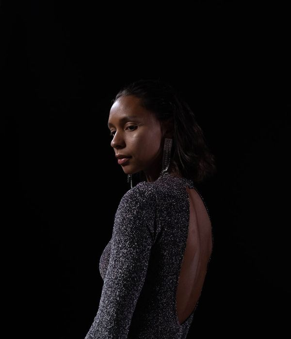 Woman in a graceful and calm stretching pose in a dark room.